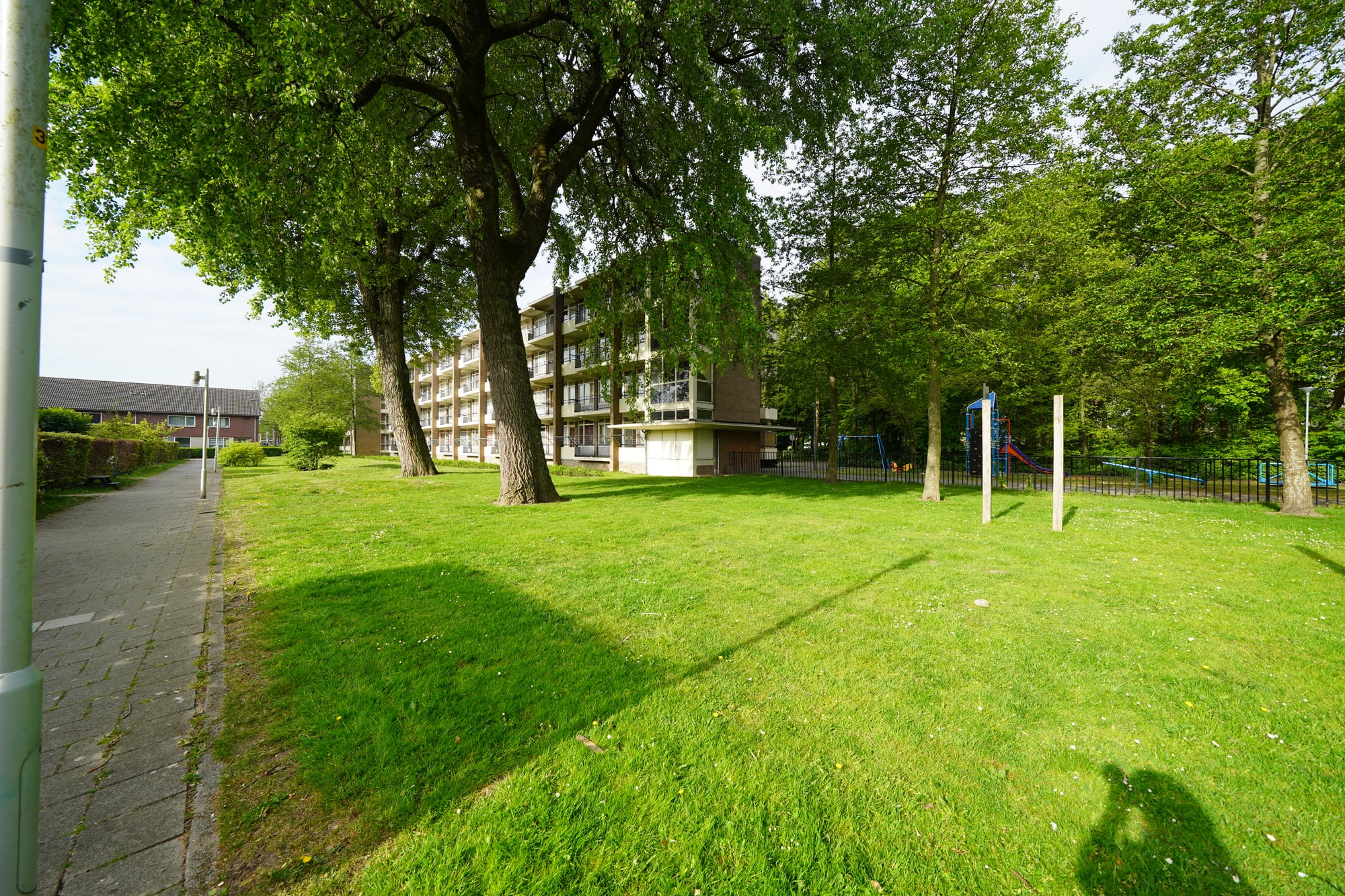 Flatgebouw te zien vanaf het grasveld