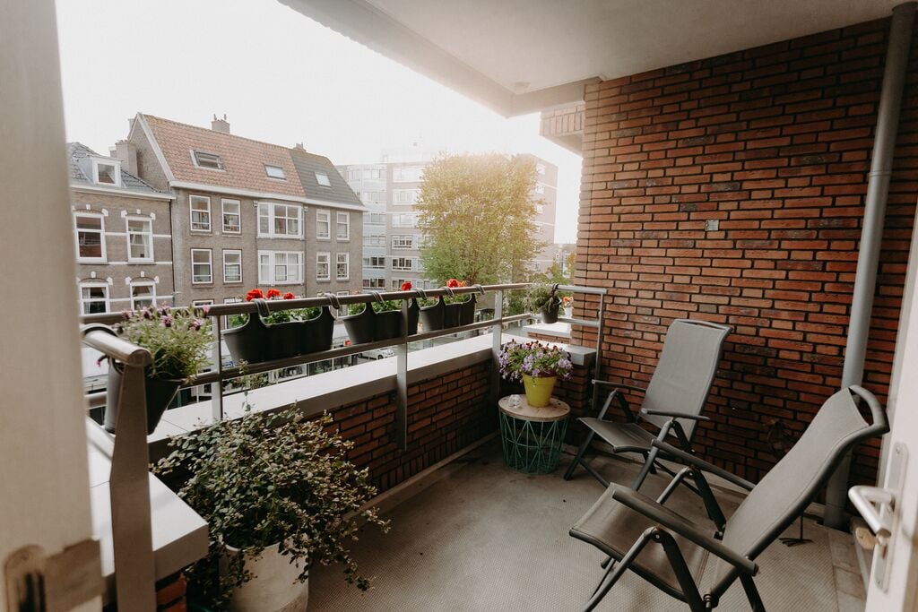 Balkon met tuinstoelen en plantenbakken