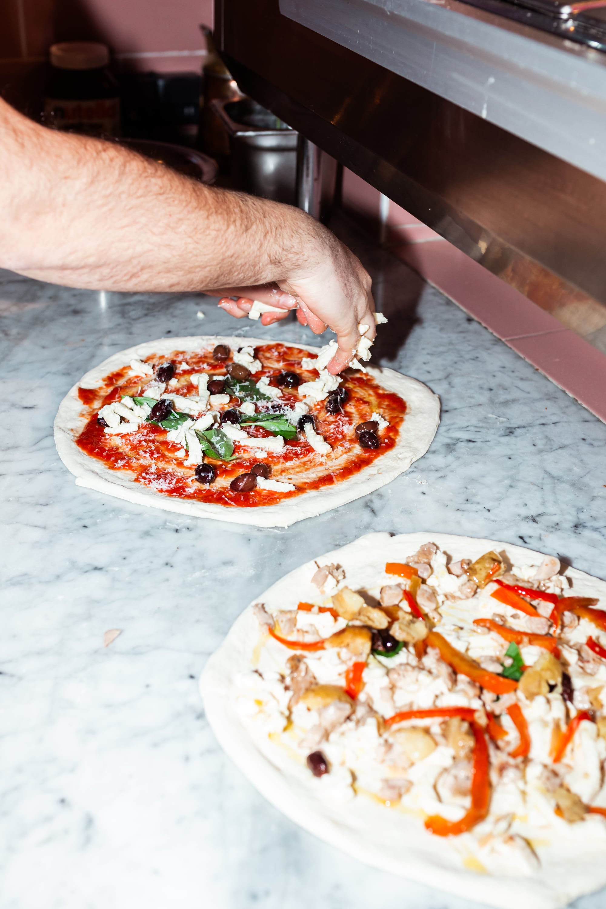 Twee pizza's die vers worden belegd