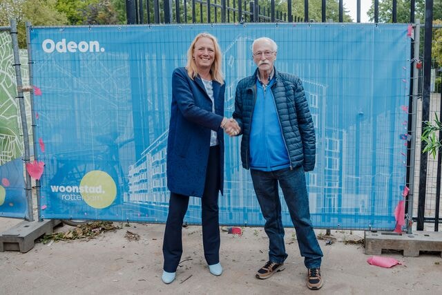 Man en vrouw schudden elkaar de hand bij de onthulling van het ontwerp van het nieuwe Odeon