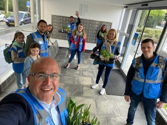 Groepsfoto met Mohamed in blauwe hesjes