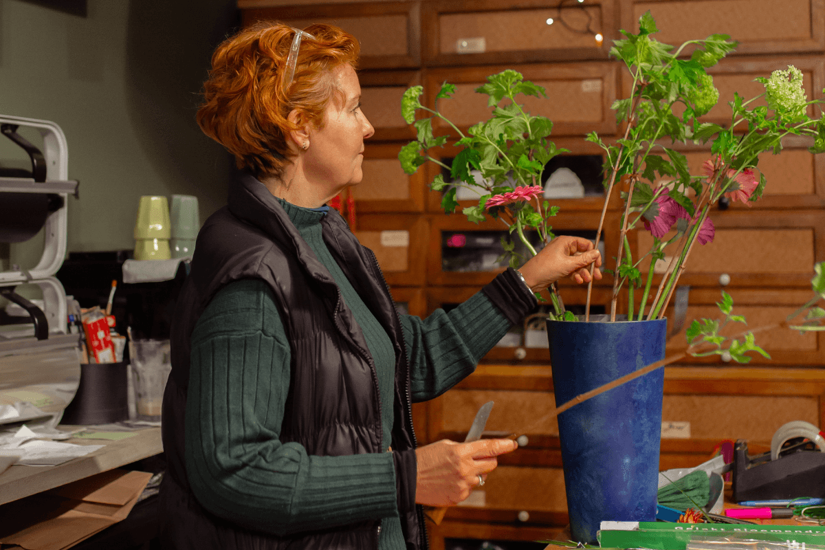 Elvira Hoogerwerf schikt bloemen in haar winkel