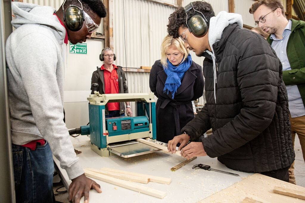 Mensen aan het werk bij opening Bouwcollege Wielewaal